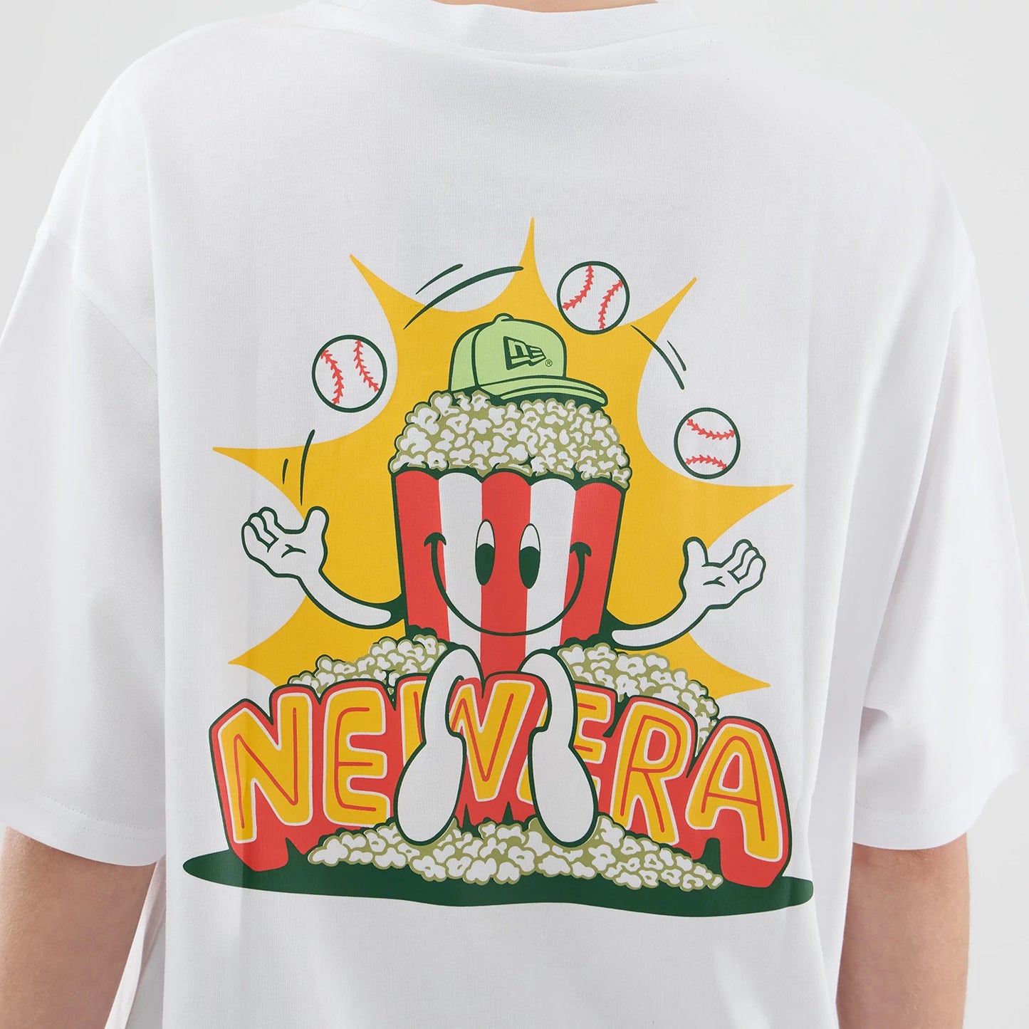 The model is wearing this New Era Baseball Popcorn Graphic Oversized T-Shirt in white. 8