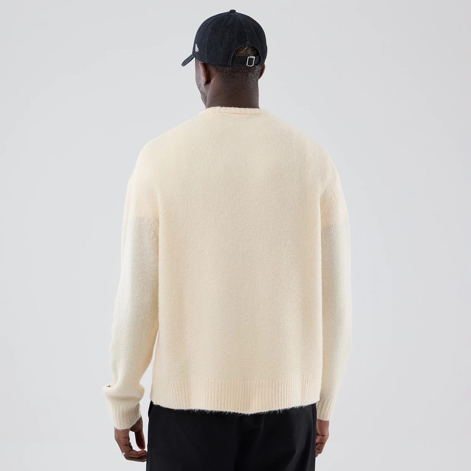 The model is wearing this New Era Knit Knitted Sweater in cream. 2