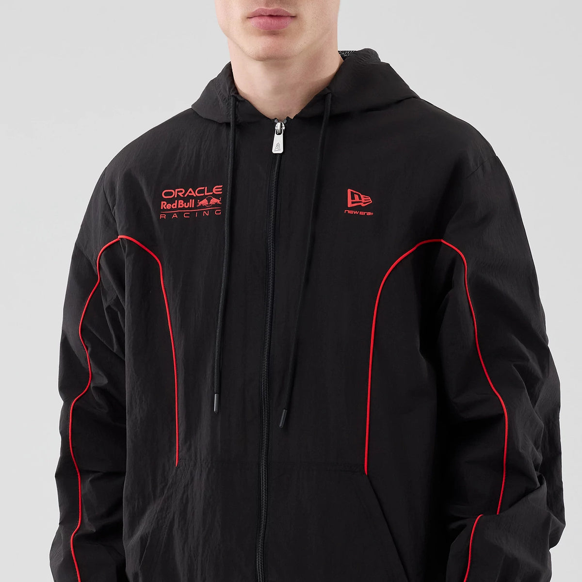 New Era Red Bull Racing Piping Black Track Jacket, front view showing red embroidered Oracle Red Bull Racing logo on the left chest, New Era logo on the right chest, red piping along the sleeves, and a zip closure at the centre.