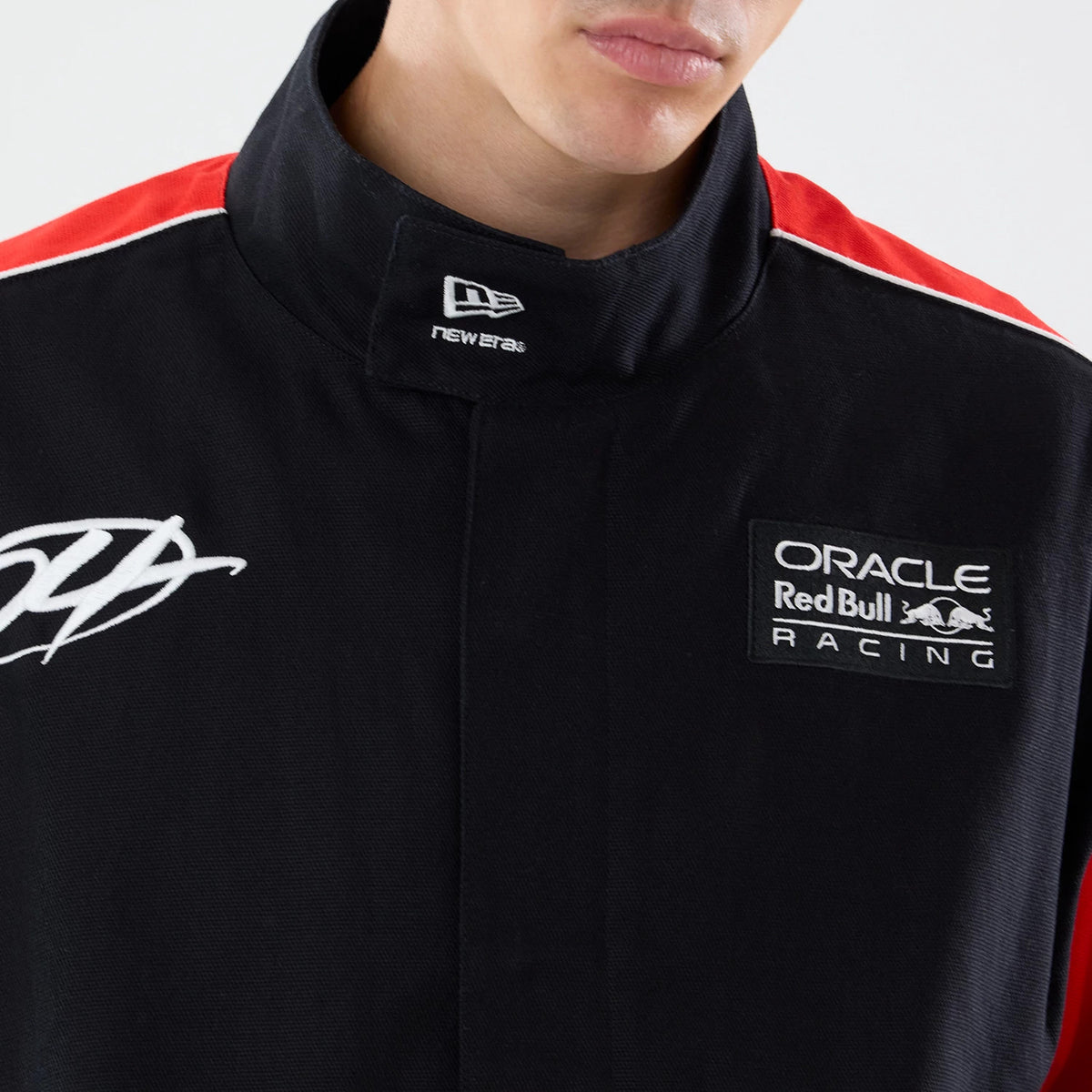 New Era Red Bull Racing Motorsport Black Jacket, front view on-model highlighting the embroidered Oracle Red Bull Racing logo on the upper left chest, a New Era logo on the collar tab, and a white graphic detail on the right shoulder.