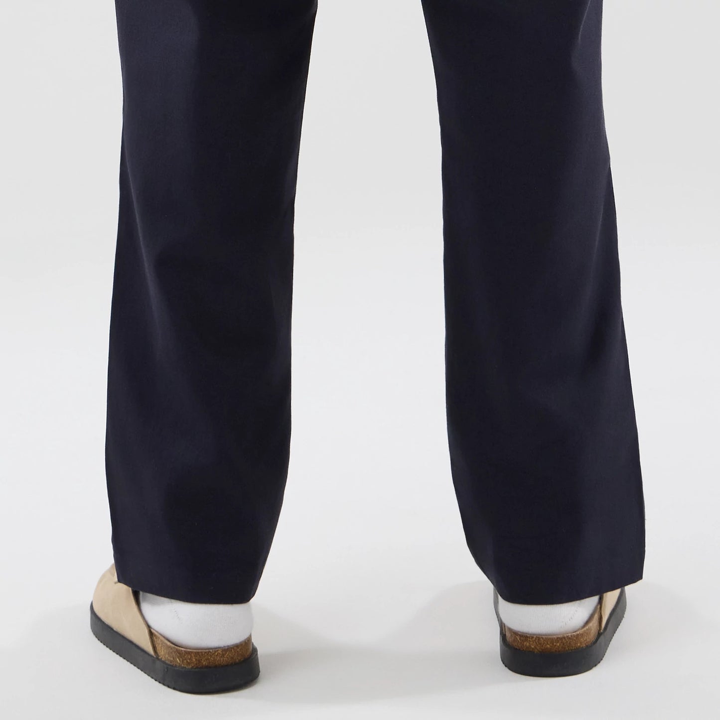 The model is wearing these New Era Chino Trousers in navy. 7