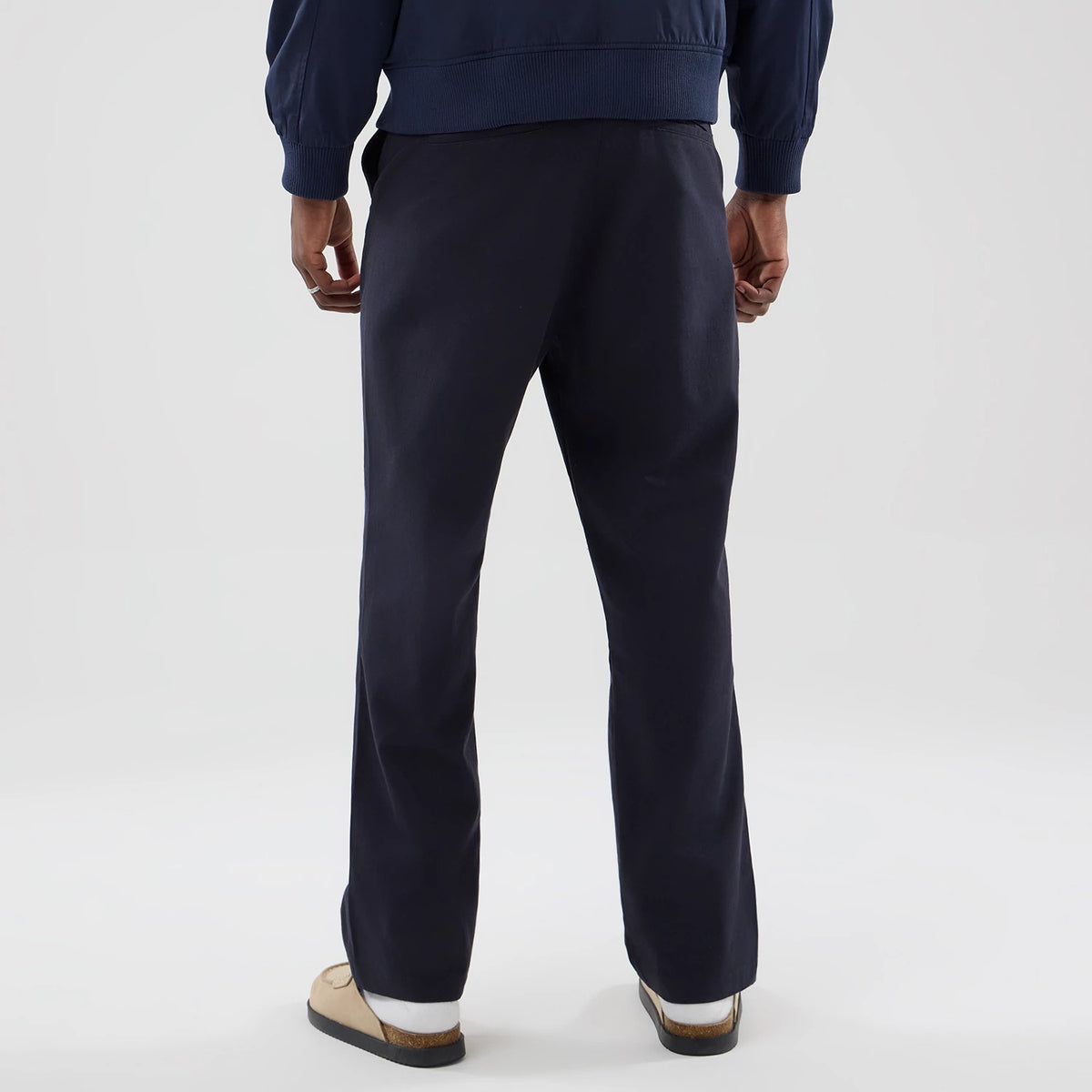 The model is wearing these New Era Chino Trousers in navy. 2