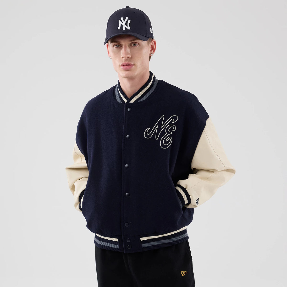 The model is wearing this New Era Oversized Varsity Jacket in navy. 3