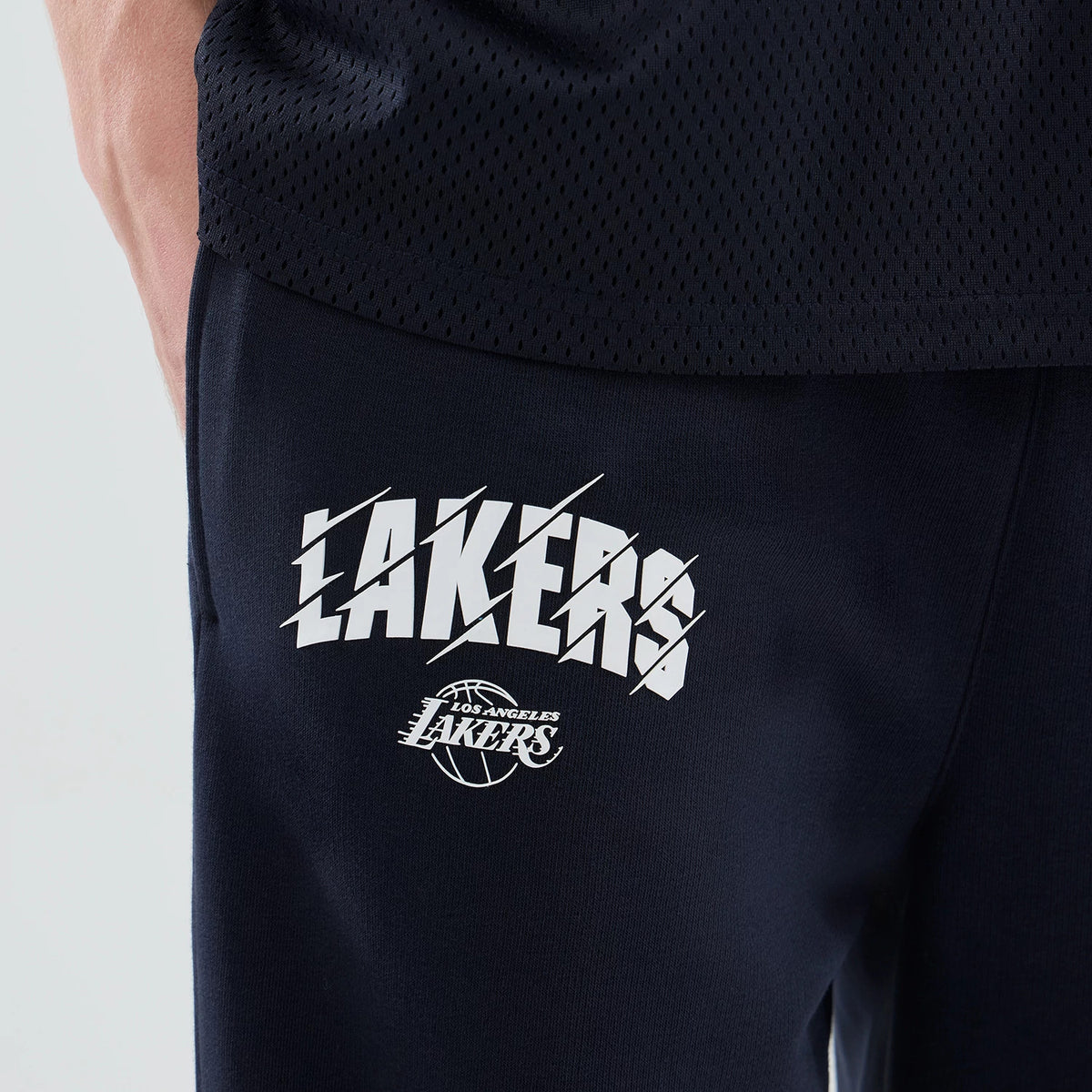 New Era LA Lakers NBA Core Plus Navy Straight Leg Joggers, close-up view showing the white Lakers logo printed on the upper thigh, accompanied by an additional smaller Lakers basketball logo below, highlighting the casual sporty design.