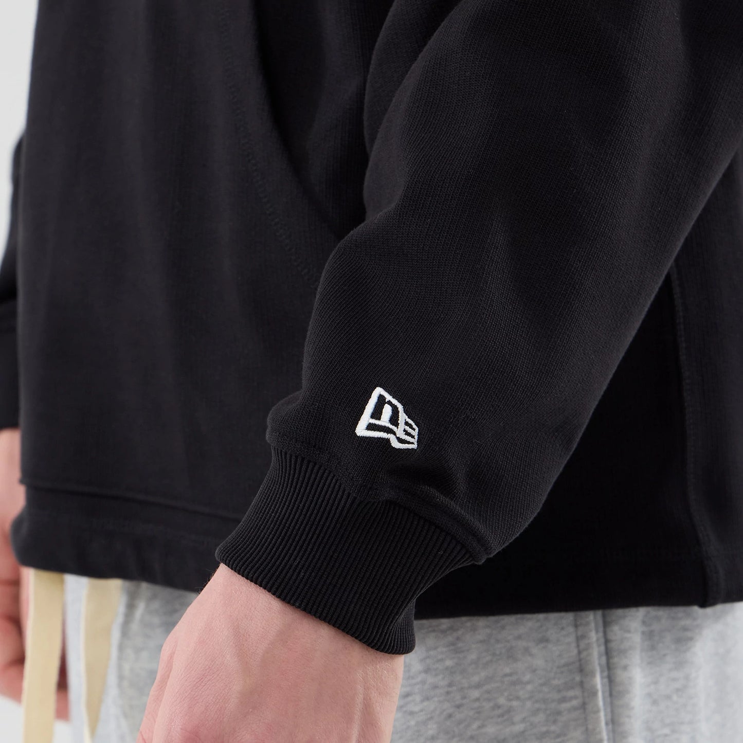 The model is wearing this New Era Open Hem Pullover Hoodie in black. 7