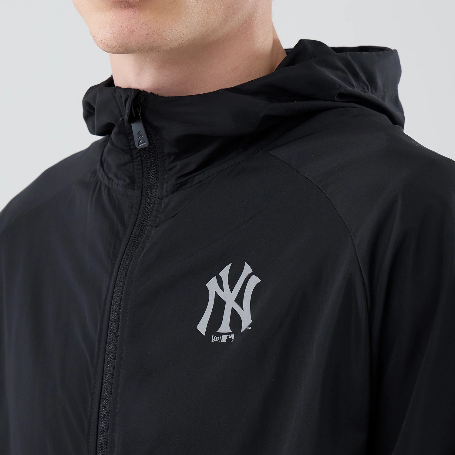 The model is wearing this MLB Core Plus Windbreaker New York Yankees Jacket in black. 4