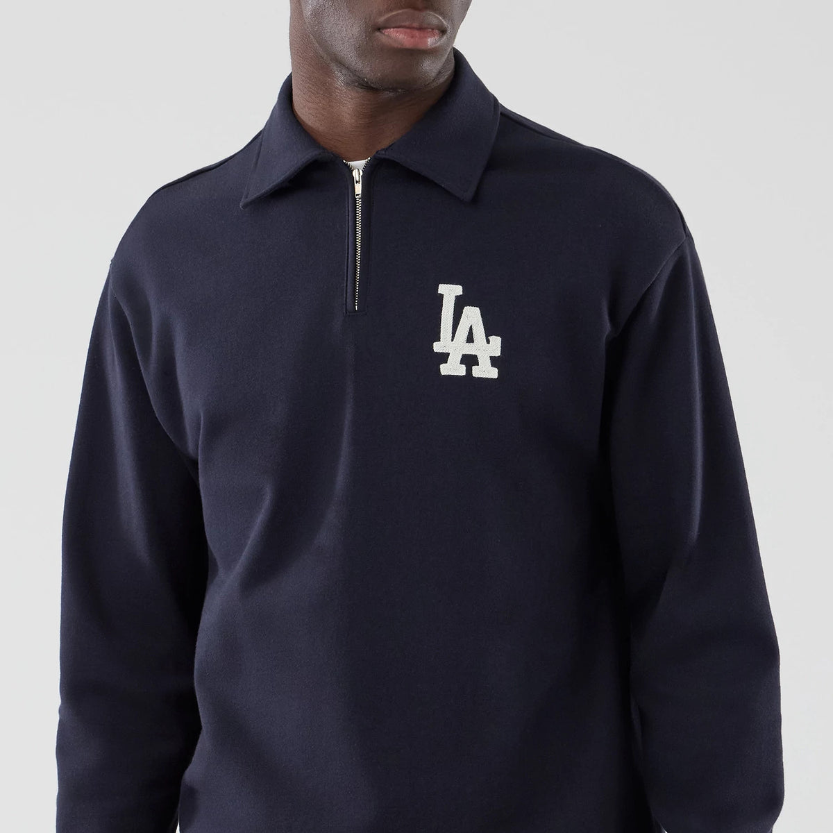 New Era LA Dodgers MLB Navy Oversized 1/4 Zip Sweater, front view with an LA logo in white embroidery on the left chest, a high collar with a quarter zip design, and long sleeves crafted in dark navy material.