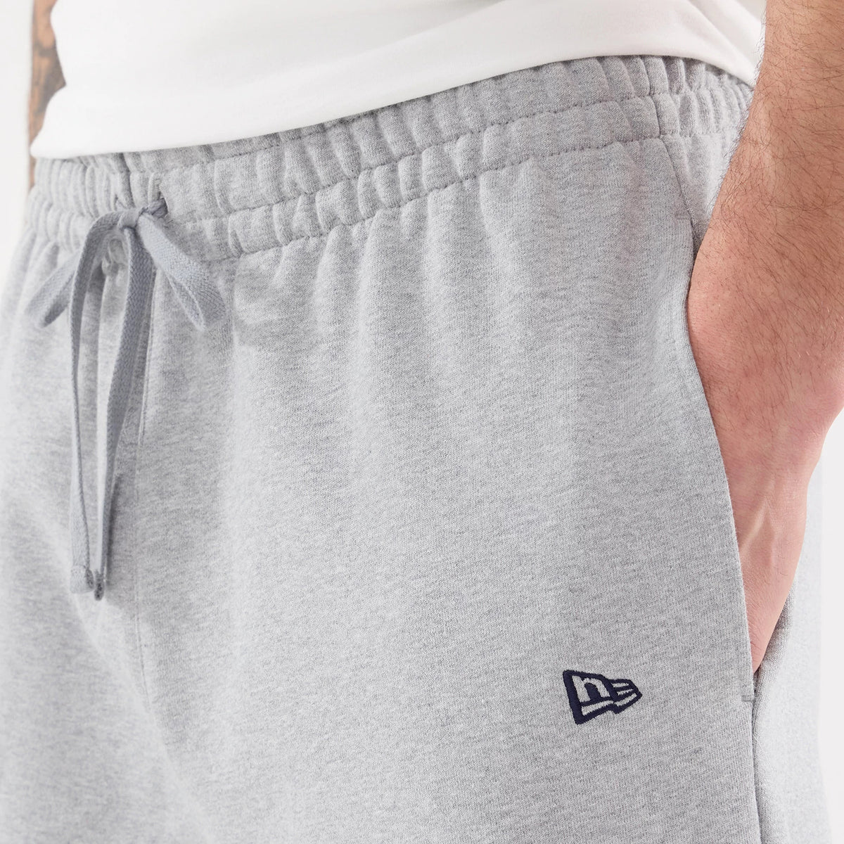 New Era New York Yankees MLB Straight Leg Grey Straight Leg Joggers, close-up view showing the elasticated waistband with a drawstring tie, side pocket, and the New Era flag logo embroidered on the left thigh in navy blue.