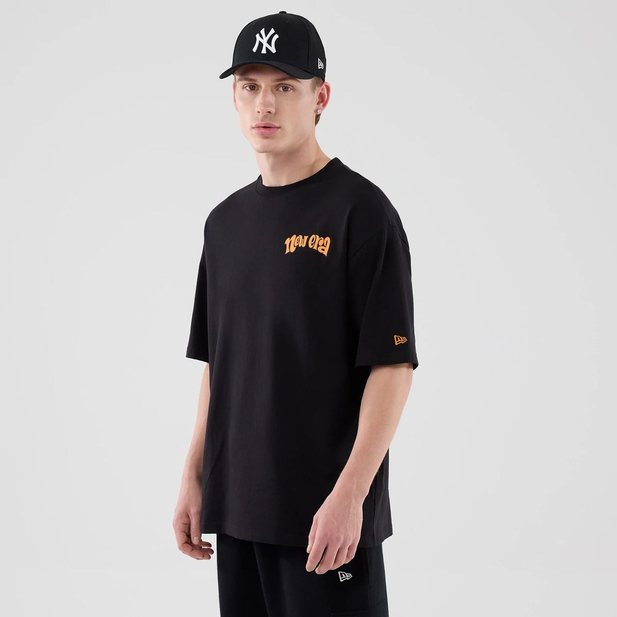 The model is wearing this New Era Hot Dog Graphic Oversized T-Shirt in black. 3