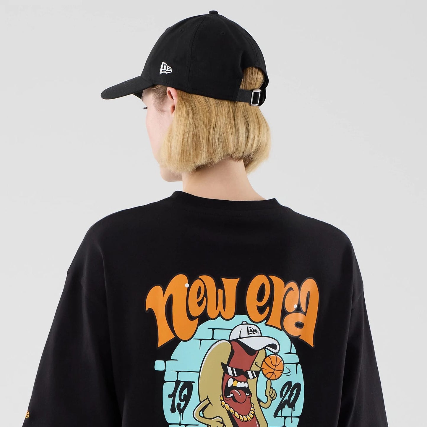 The model is wearing this New Era Food Graphic Oversized T-Shirt in black. 8