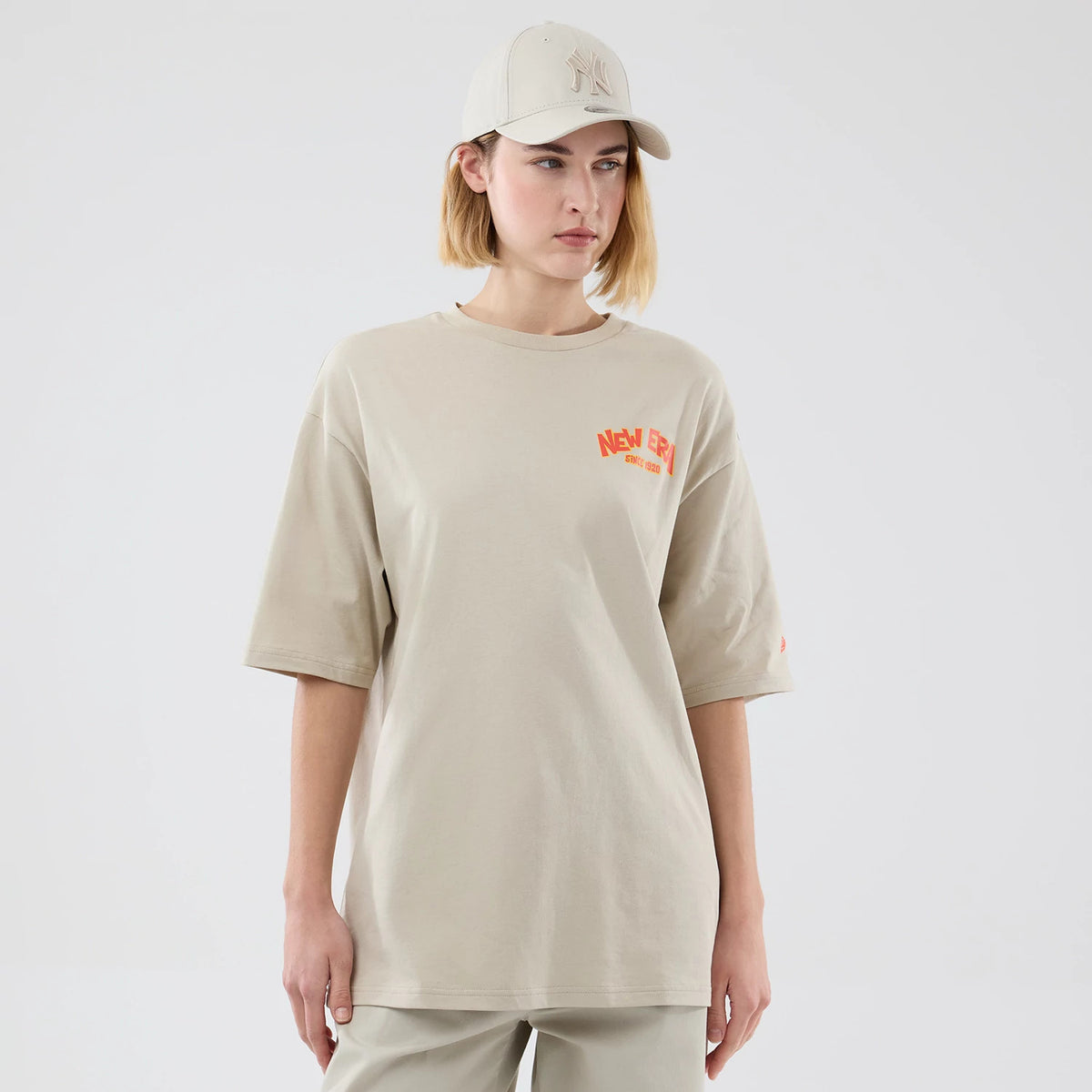 The model is wearing this New Era Food Graphic Oversized T-Shirt in light beige. 4