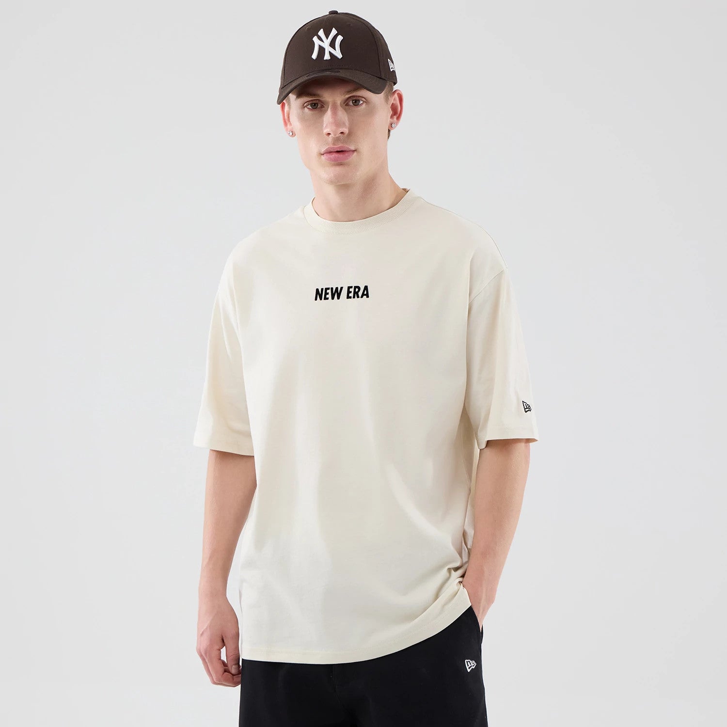 The model is wearing this New Era Cap Graphic Oversized T-Shirt in cream. 3