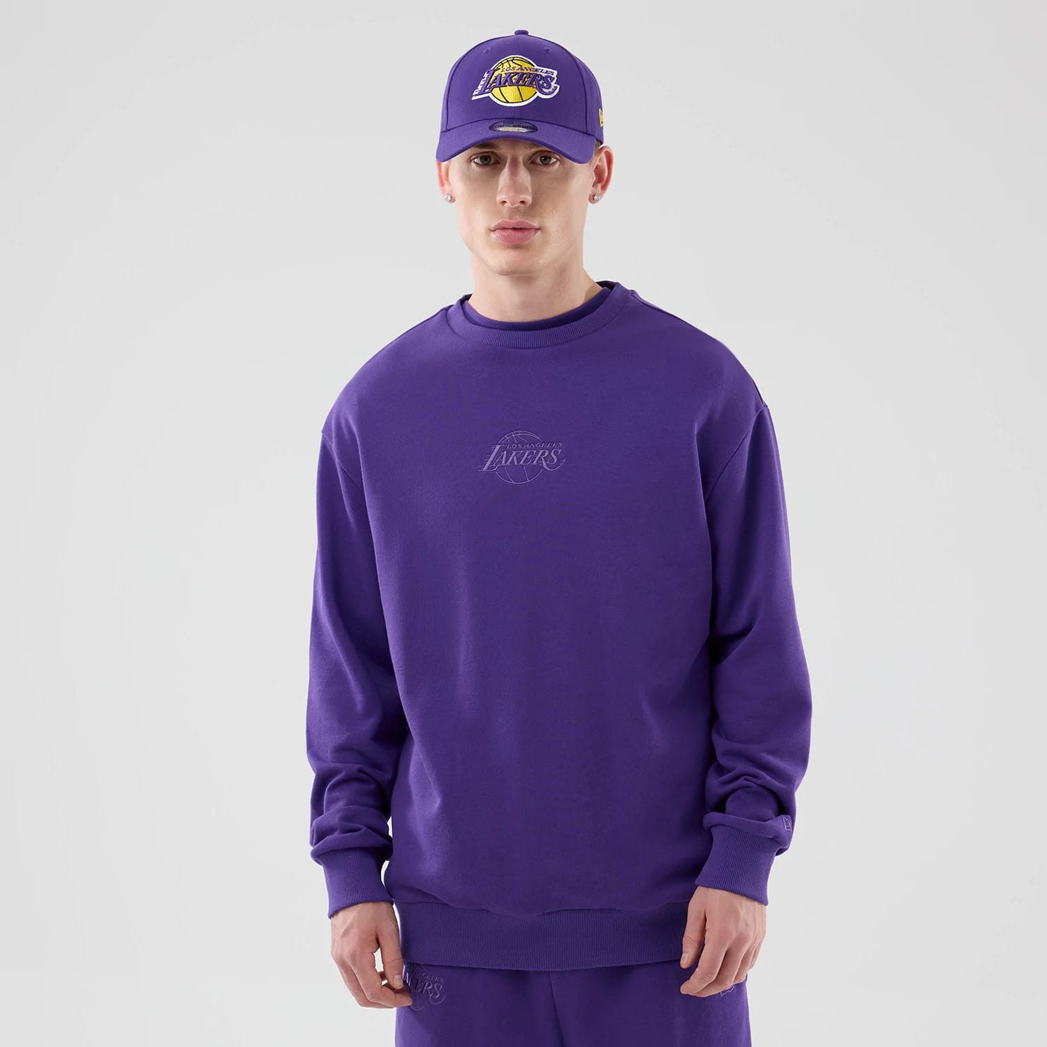 The model is wearing this NBA League Essential LA Lakers Oversized Crew Neck Sweater in purple. 1