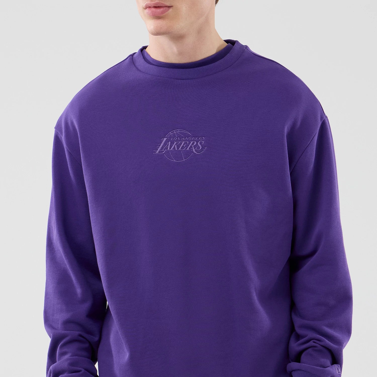 The model is wearing this NBA League Essential LA Lakers Oversized Crew Neck Sweater in purple. 3