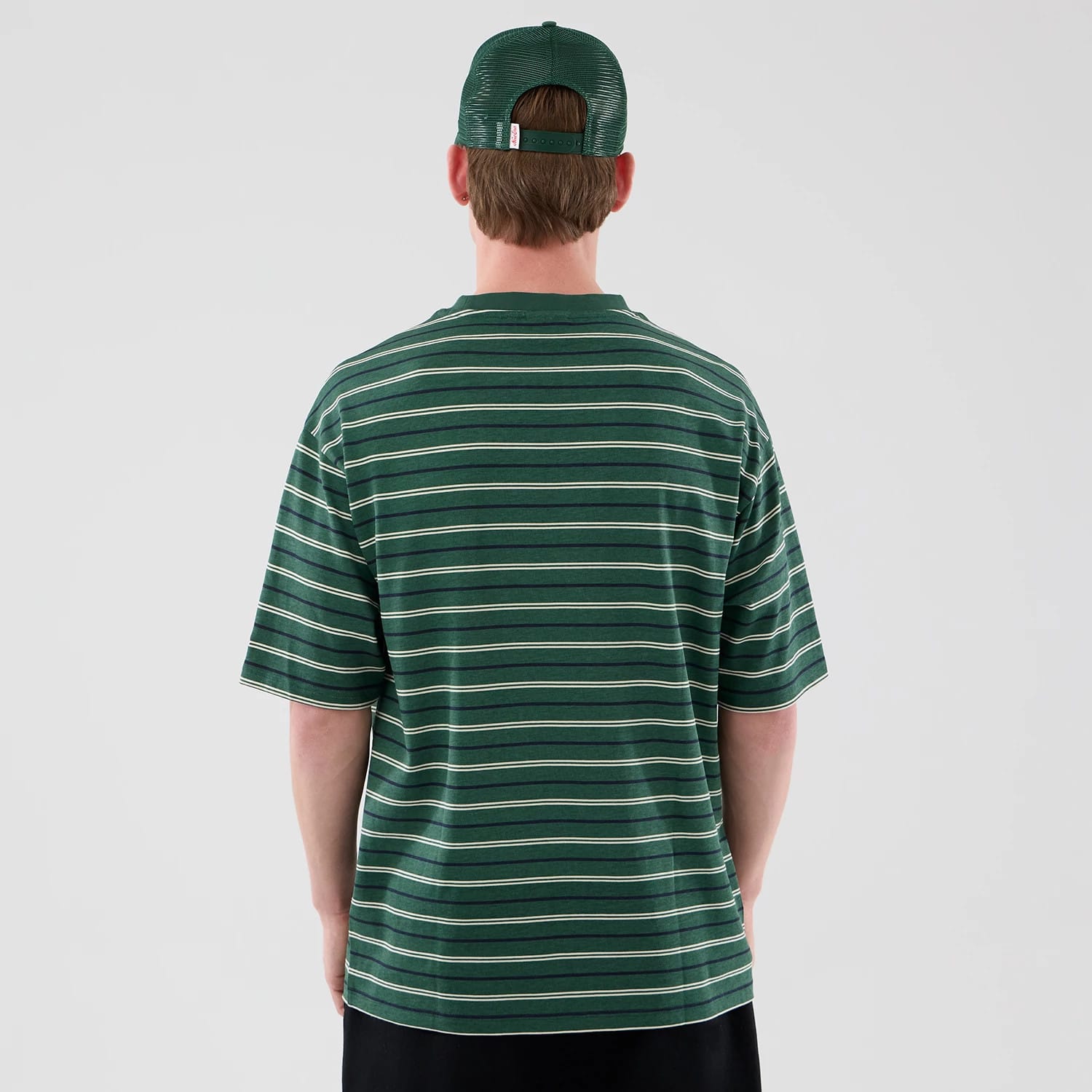 The model is wearing this New Era Stripe Oversized T-Shirt in dark green. 2
