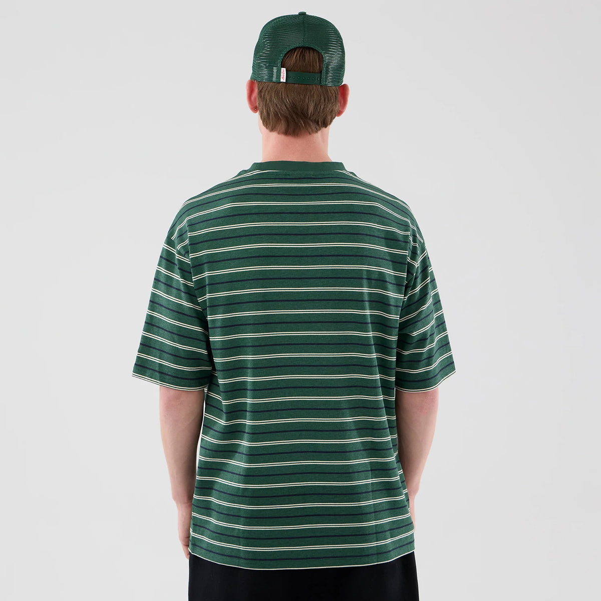 The model is wearing this New Era Stripe Oversized T-Shirt in dark green. 2