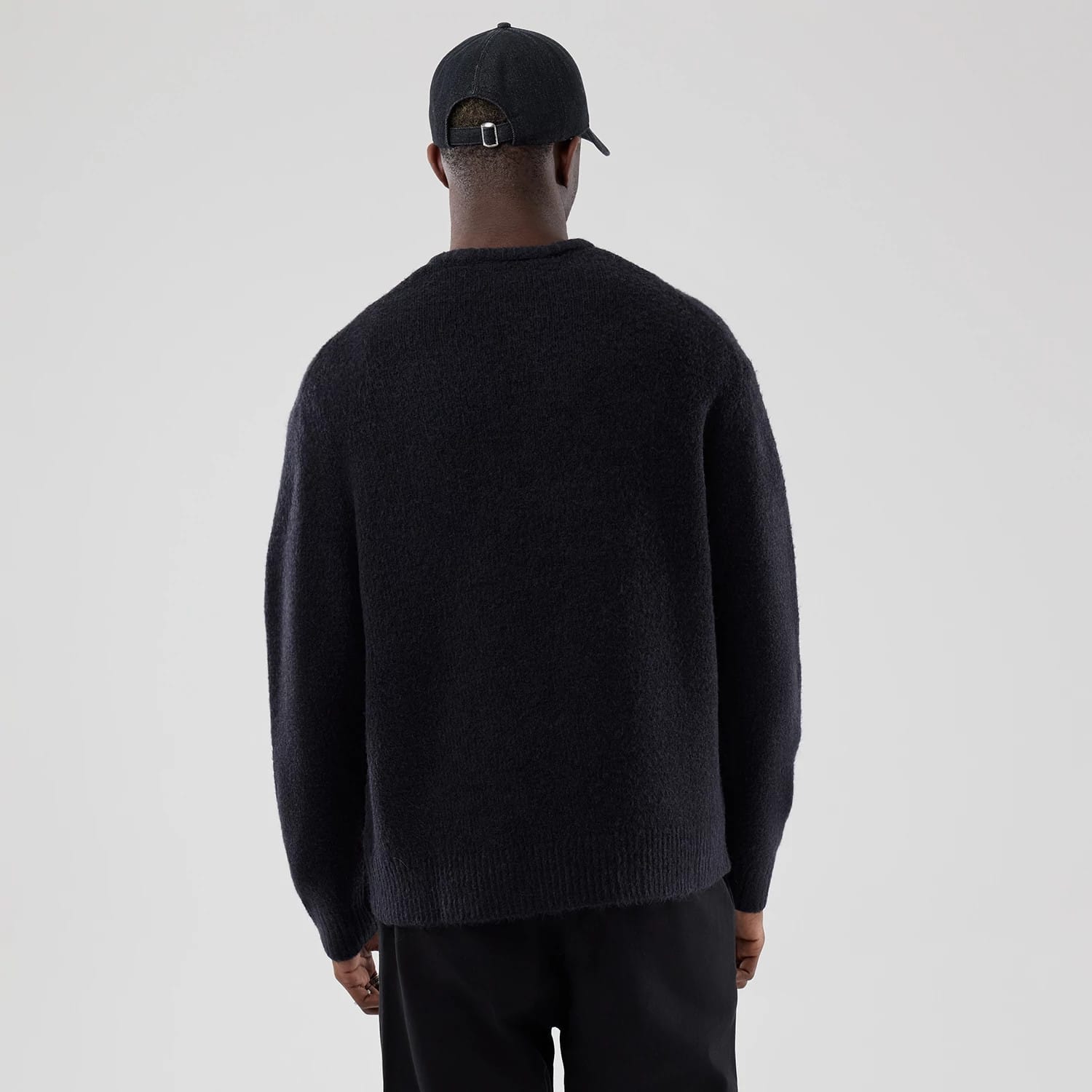 The model is wearing this New Era Knit Heritage Knitted Sweater in navy. 2
