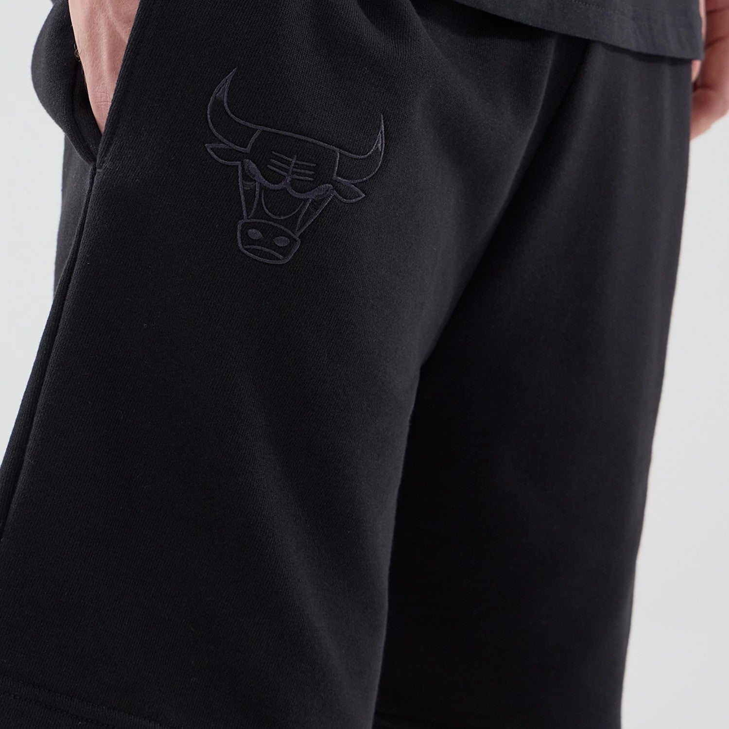 The model is wearing these NBA League Essential Chicago Bulls Oversized Shorts in black. 4