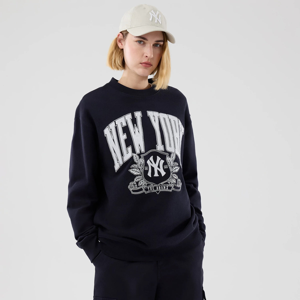 The model is wearing this MLB Arch Graphic New York Yankees Oversized Crew Neck Sweater in navy. 4