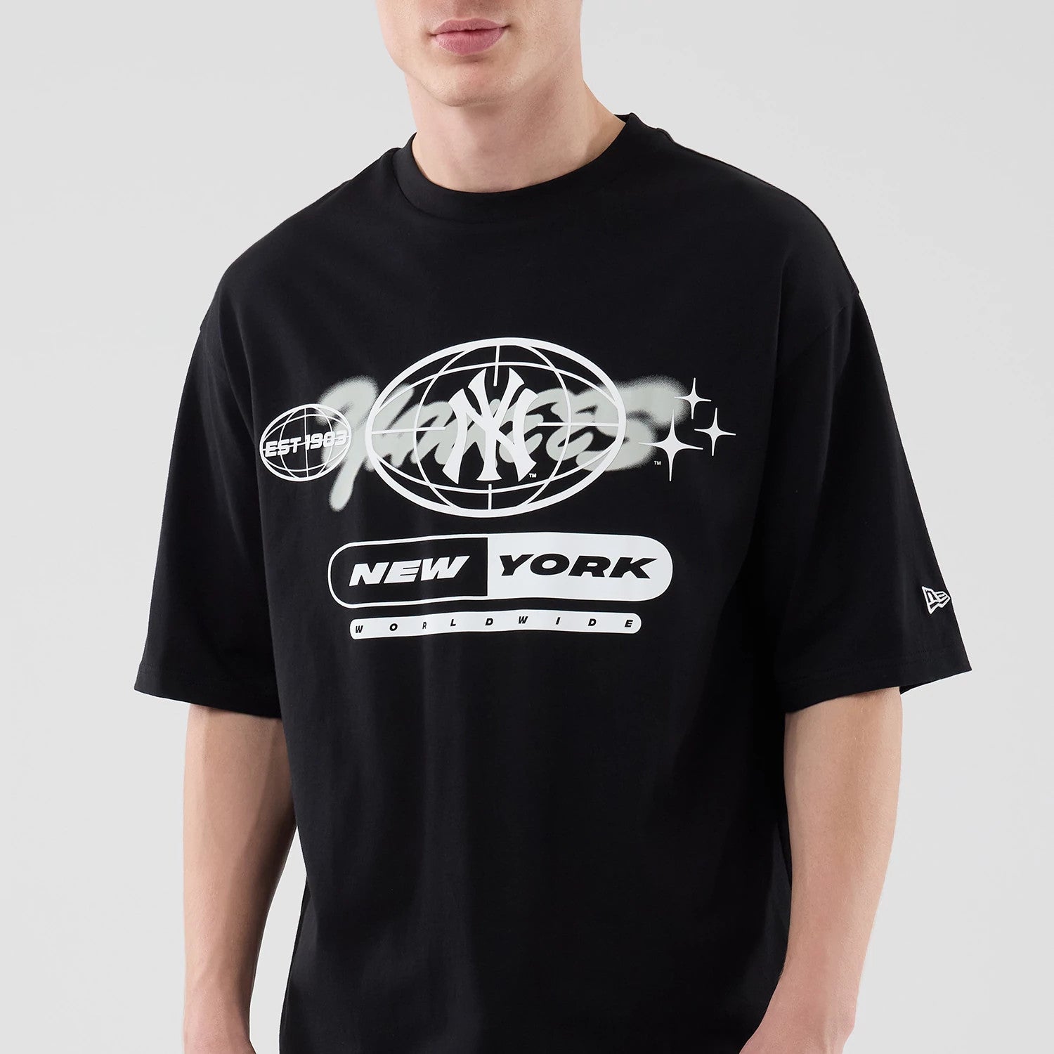 The model is wearing this MLB Logo Graphic New York Yankees Oversized T-Shirt in black. 4