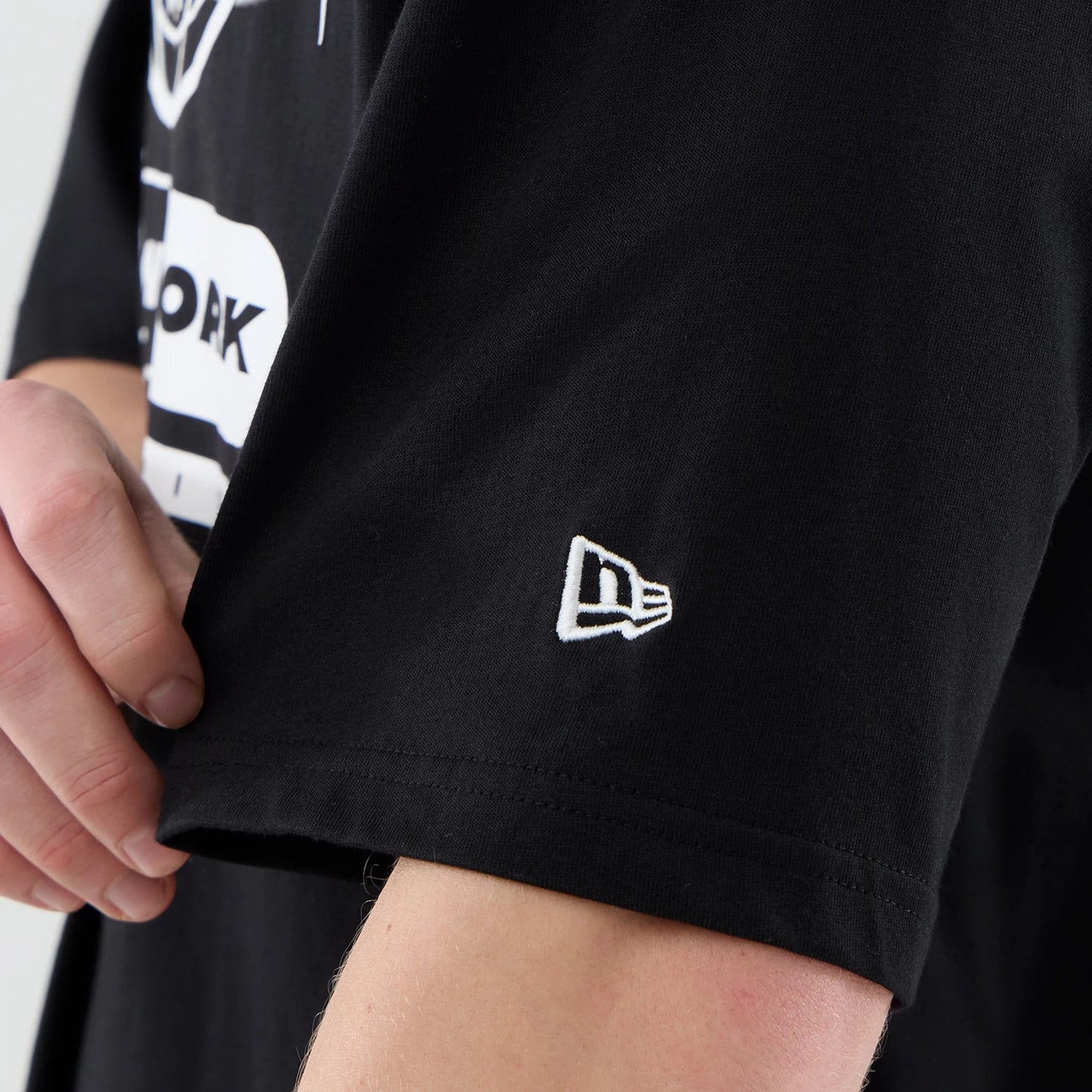 The model is wearing this MLB Logo Graphic New York Yankees Oversized T-Shirt in black. 7