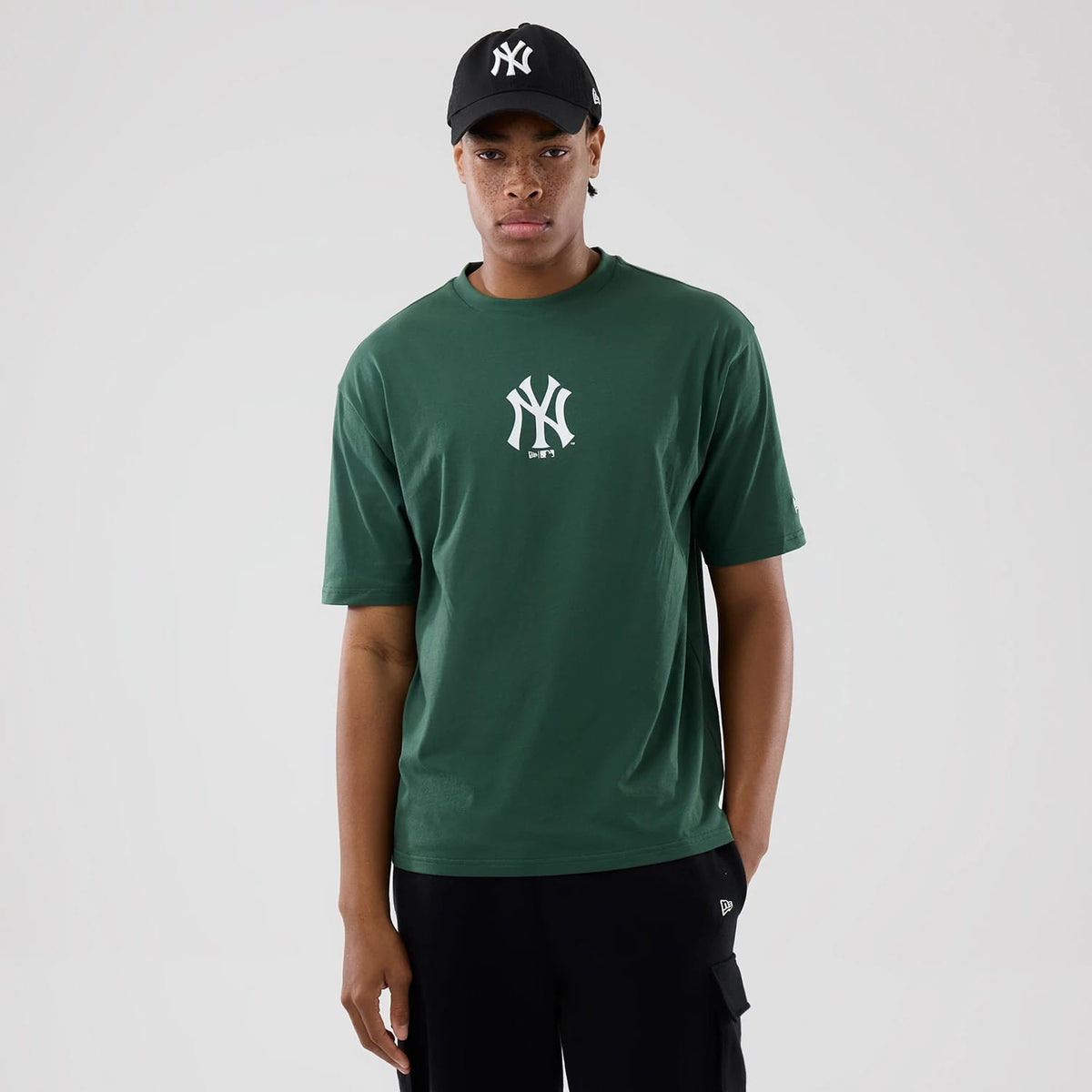 The model is wearing this MLB Food Graphic New York Yankees Oversized T-Shirt in dark green. 1