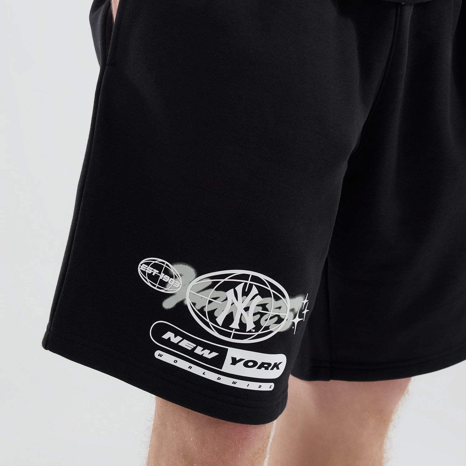 The model is wearing these MLB Logo Graphic New York Yankees Oversized Shorts in black. 4