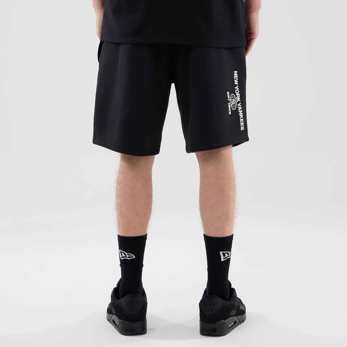 The model is wearing these MLB Logo Graphic New York Yankees Oversized Shorts in black. 2