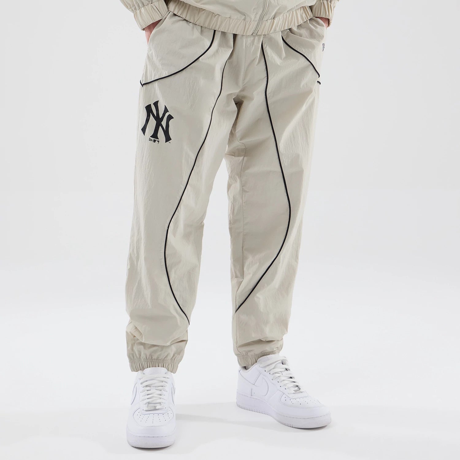 The model is wearing these MLB Piping Track New York Yankees Track Pants in cream. 1