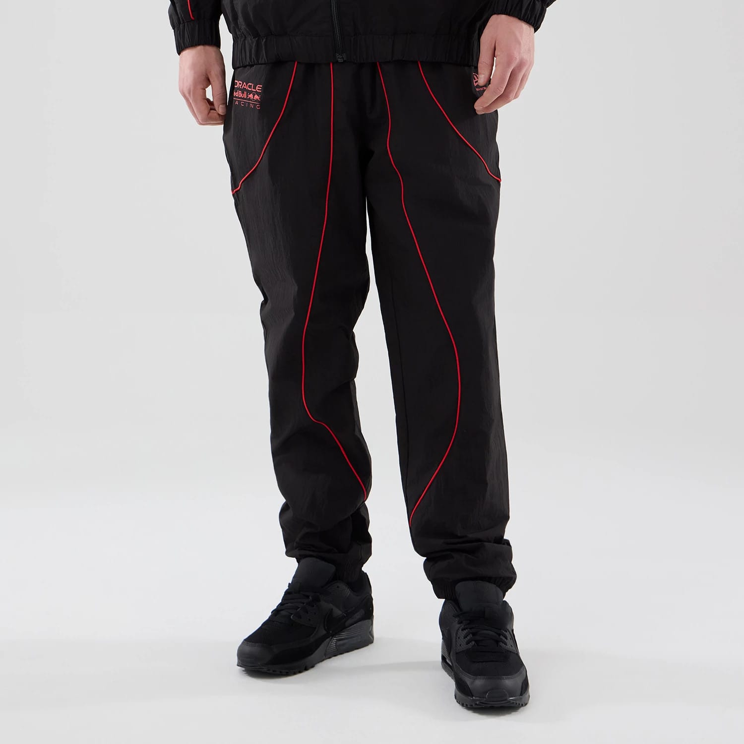 The model is wearing these Red Bull Racing Piping Track Pants in black. 1