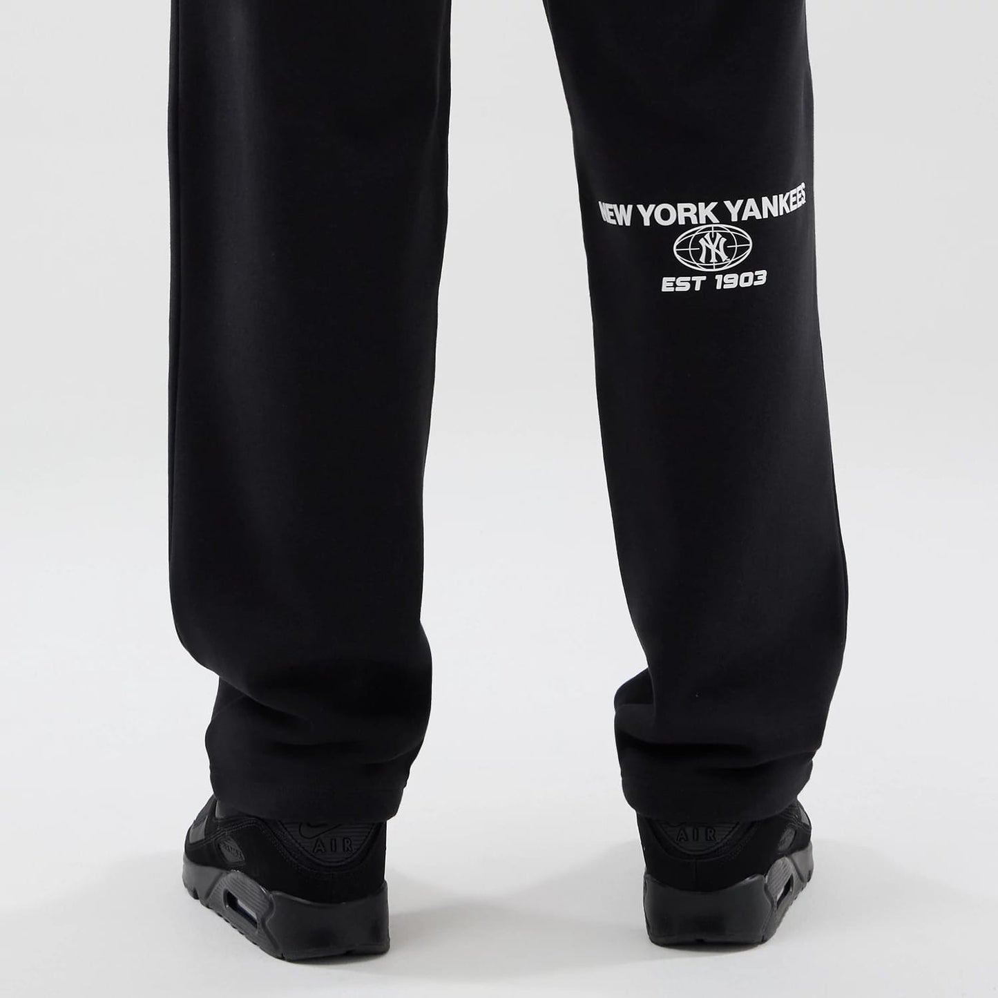 The model is wearing these MLB Logo Graphic New York Yankees Straight Leg Joggers in black. 7