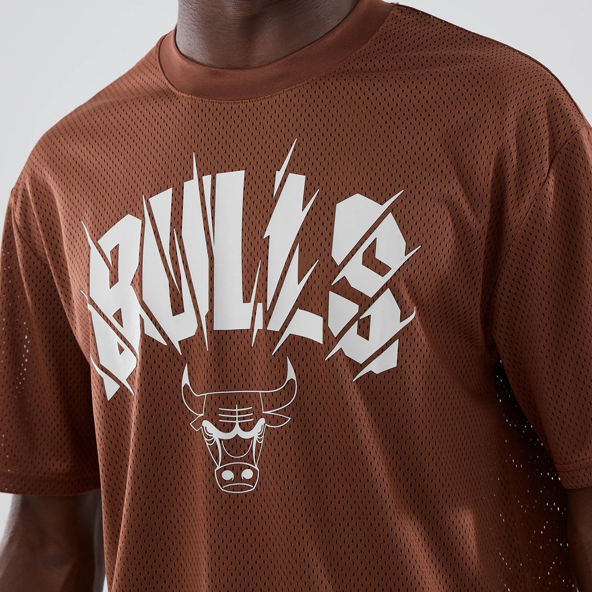 The model is wearing this NBA Core Plus Mesh Chicago Bulls Oversized T-Shirt in brown. 4