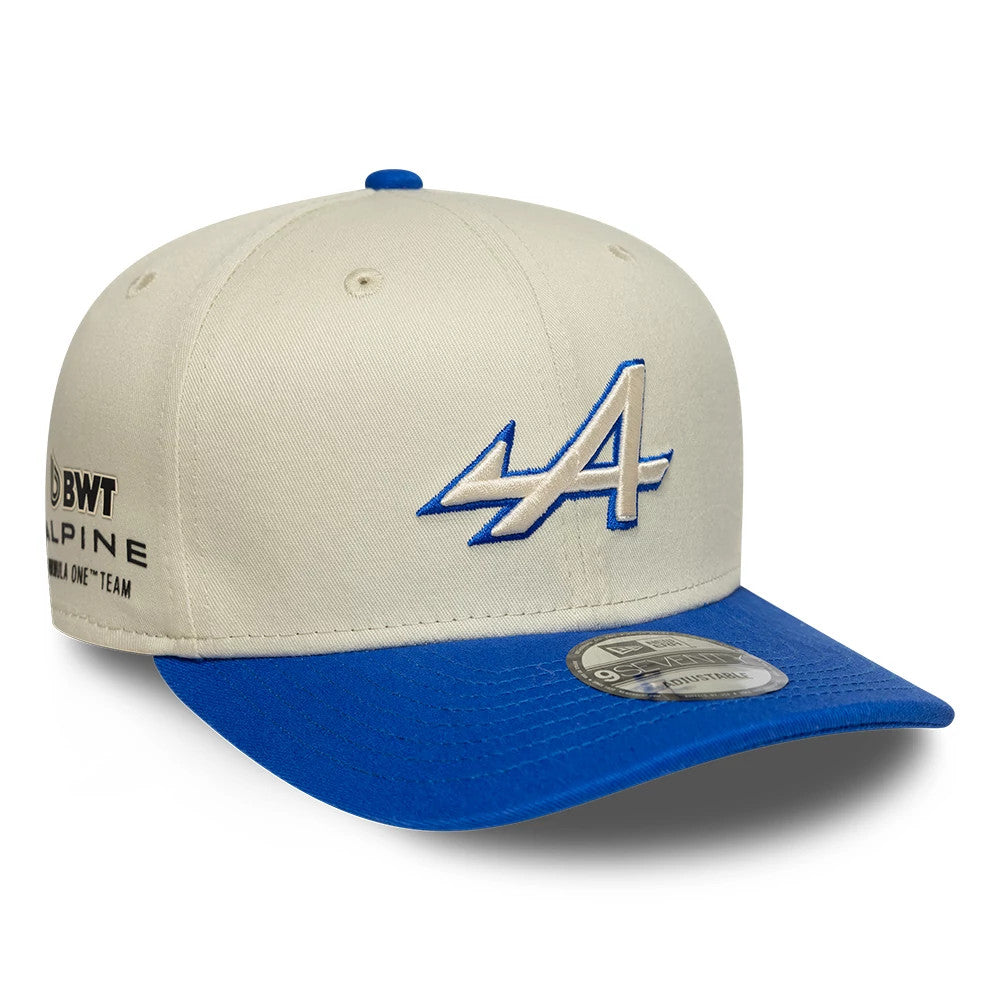 Alpine Racing Contrast Visor Cream New Era 9SEVENTY Stretch Snap Adjustable Cap, front view showing the blue-and-white embroidered A logo on the cream front panel, blue curved visor with 9SEVENTY size sticker.