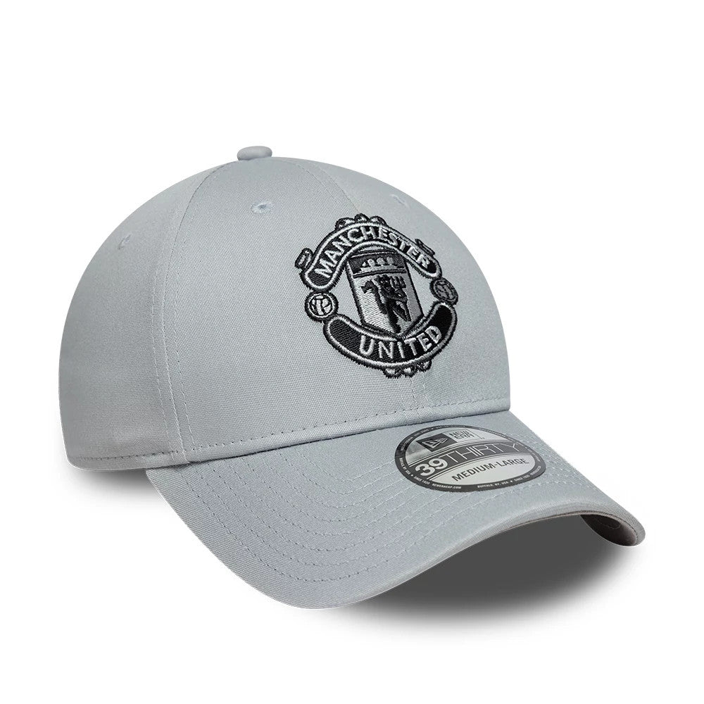 Manchester United FC Grey New Era 39THIRTY Stretch Fit Cap, three-quarter view showing a black embroidered Manchester United crest on the front panel, with a slightly curved grey visor and a 39THIRTY size sticker on the top.