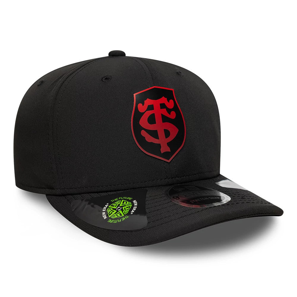 Stade Toulousain Gradient Black New Era 9SEVENTY Stretch Snap Adjustable Cap, three-quarter view showing the red embroidered team logo on the front panel, matching black visor with two size stickers, and top button with eyelets.