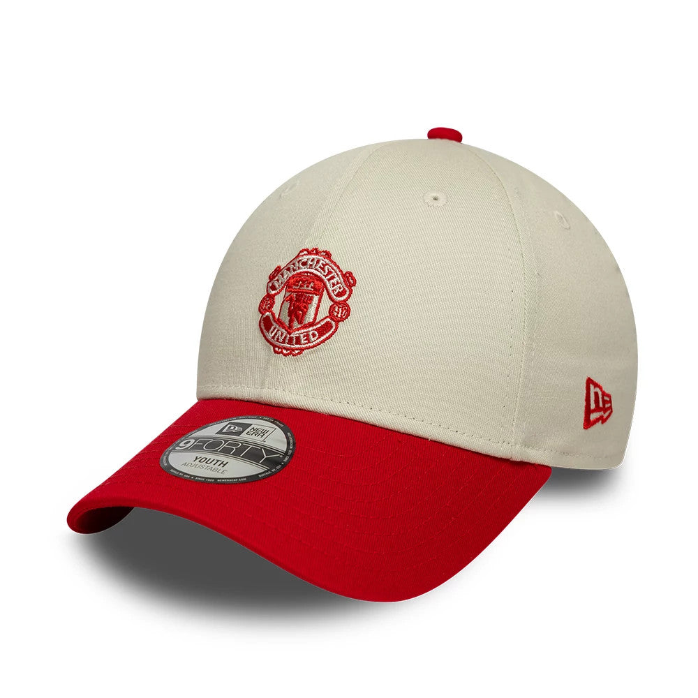 Youth Manchester United FC Contrast Cream New Era 9FORTY Adjustable Cap, three-quarter view showing the red embroidered Manchester United crest on the front panel, matching red visor and red New Era flag logo on the left side.