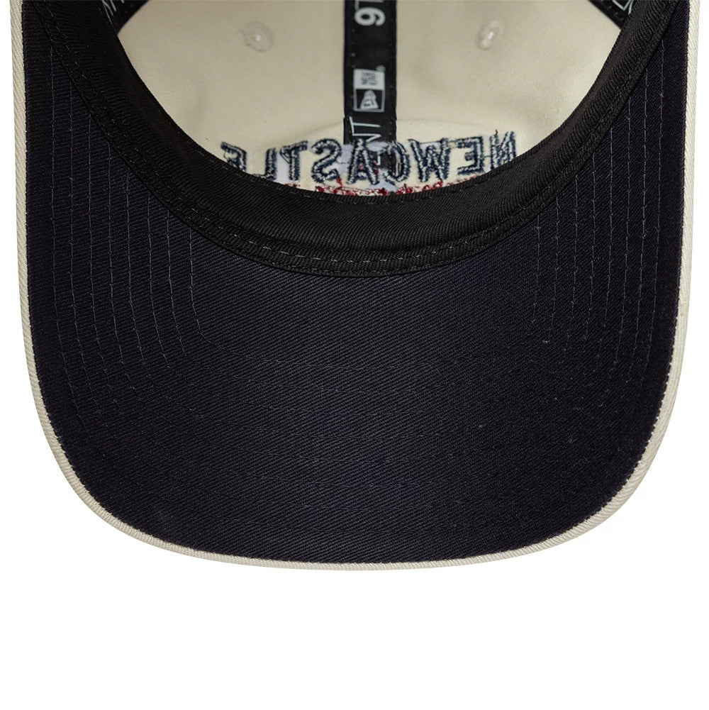 Newcastle United FC Howay The Lads Cream New Era 9TWENTY Adjustable Cap, inside view showing the black taping with white details, a cream sweatband, and a dark navy undervisor contrasting with the cream interior fabric.