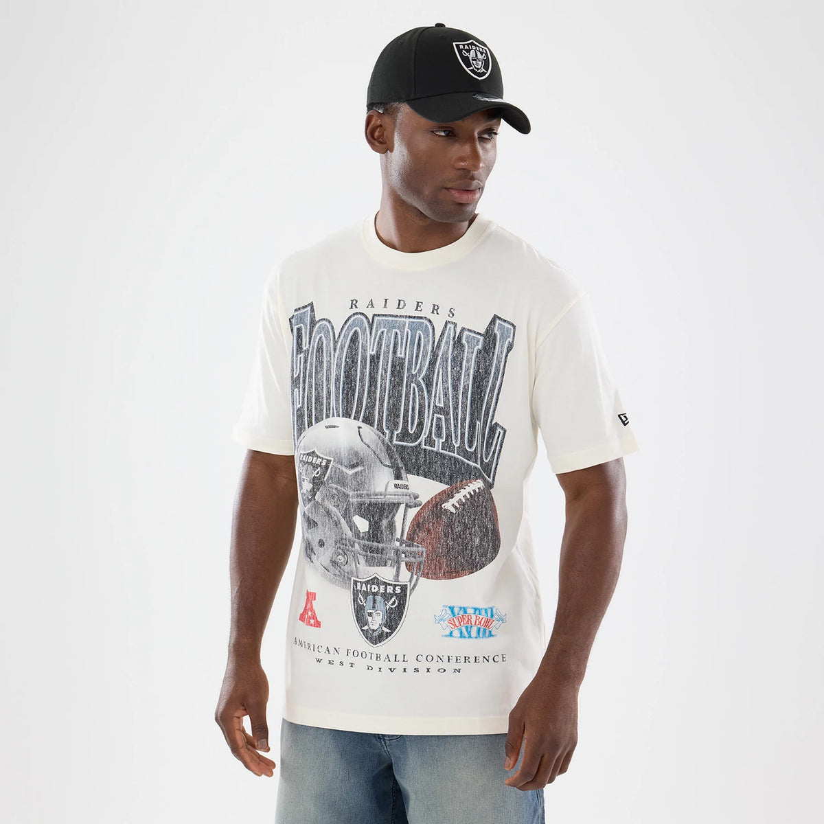 New Era Las Vegas Raiders NFL Sport Classic Cream T-Shirt, front view on-model showing Football lettering above a large image of a Raiders helmet and football, small conference logos below, and a New Era flag embroidered on the left sleeve.