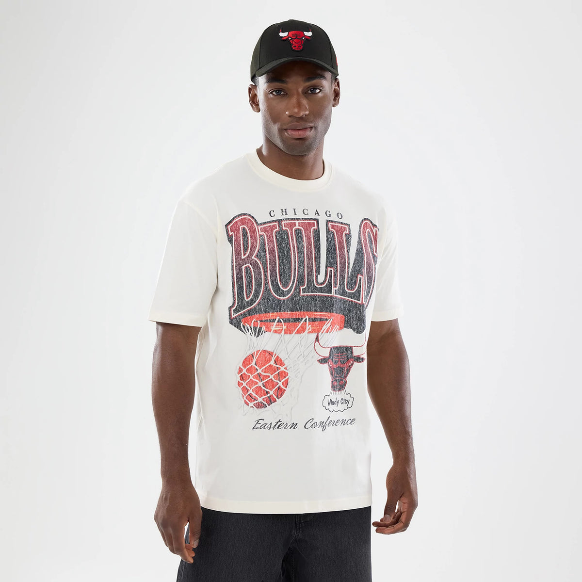 New Era Chicago Bulls NBA Sport Classic Cream T-Shirt, front view on-model showing a large BULLS graphic in black and red across the chest with a basketball and hoop graphic below, and Eastern Conference lettering near the hem.