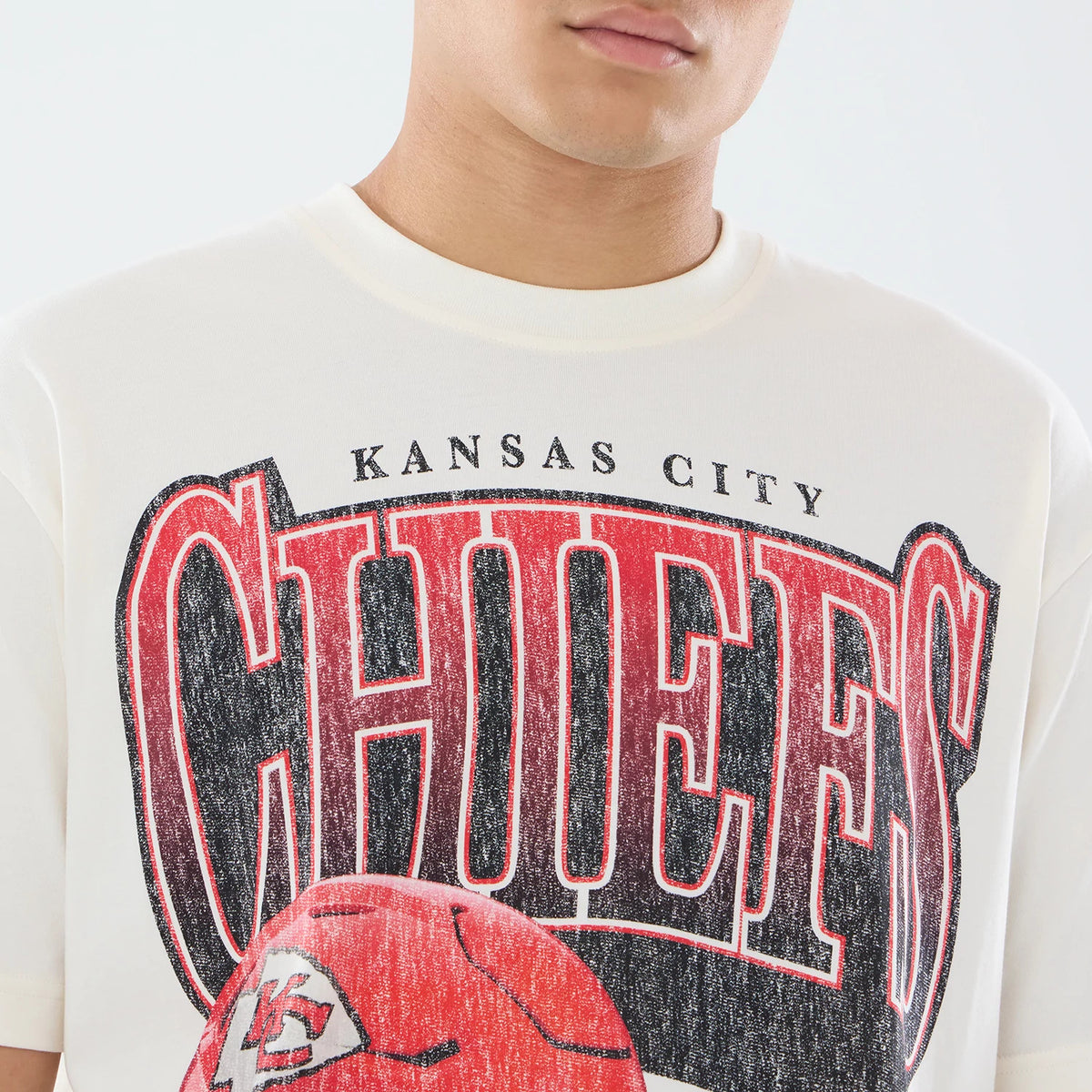 New Era Kansas City Chiefs NFL Sport Classic Cream T-Shirt, front view showing large distressed red CHIEFS lettering across the chest with a black outline, KANSAS CITY above and a red football graphic with the team logo below.