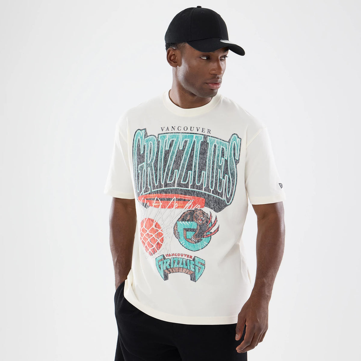New Era Vancouver Grizzlies NBA Sport Classic Cream T-Shirt, front view on a model styled with a black cap, featuring a large distressed Grizzlies graphic with a turquoise-outline bear claw gripping a basketball.