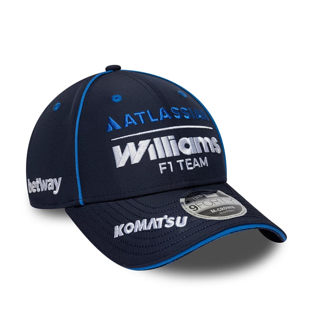 Williams Team Navy New Era 9FORTY M-Crown Adjustable Cap, three-quarter view showing raised white Williams F1 Team embroidery on the structured navy crown, with blue piping and eyelets, and a 9FORTY size sticker on the curved navy visor.