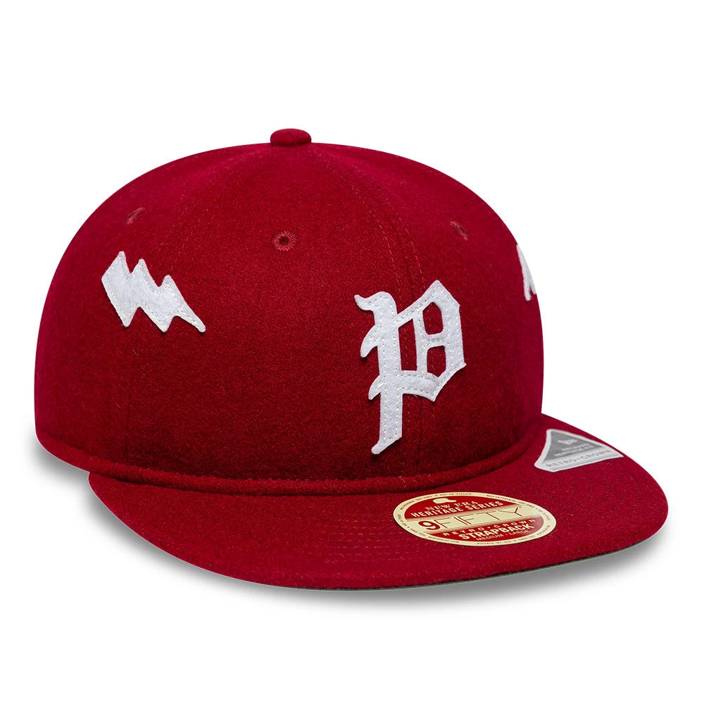 Phillies MLB Heritage Dark Red Retro Crown New Era 9FIFTY Adjustable Cap, three-quarter view showing the white embroidered P logo on the front panel, a unique character symbol on the side, and a gold 9FIFTY size sticker on the red visor.