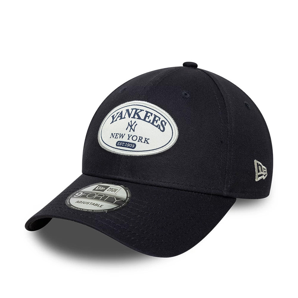 New York Yankees MLB Patch Navy New Era 9FORTY Adjustable Cap, three-quarter view showing the embroidered Yankees patch on the front panel, with a silver 9FORTY size sticker on the curved navy visor and the New Era flag logo on the left side.