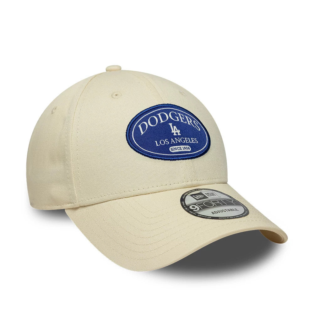LA Dodgers MLB Patch Cream New Era 9FORTY Adjustable Cap, front view showing a blue embroidered Dodgers patch with Los Angeles text on the front panels, a curved cream visor, and a 9FORTY size sticker on the visor.