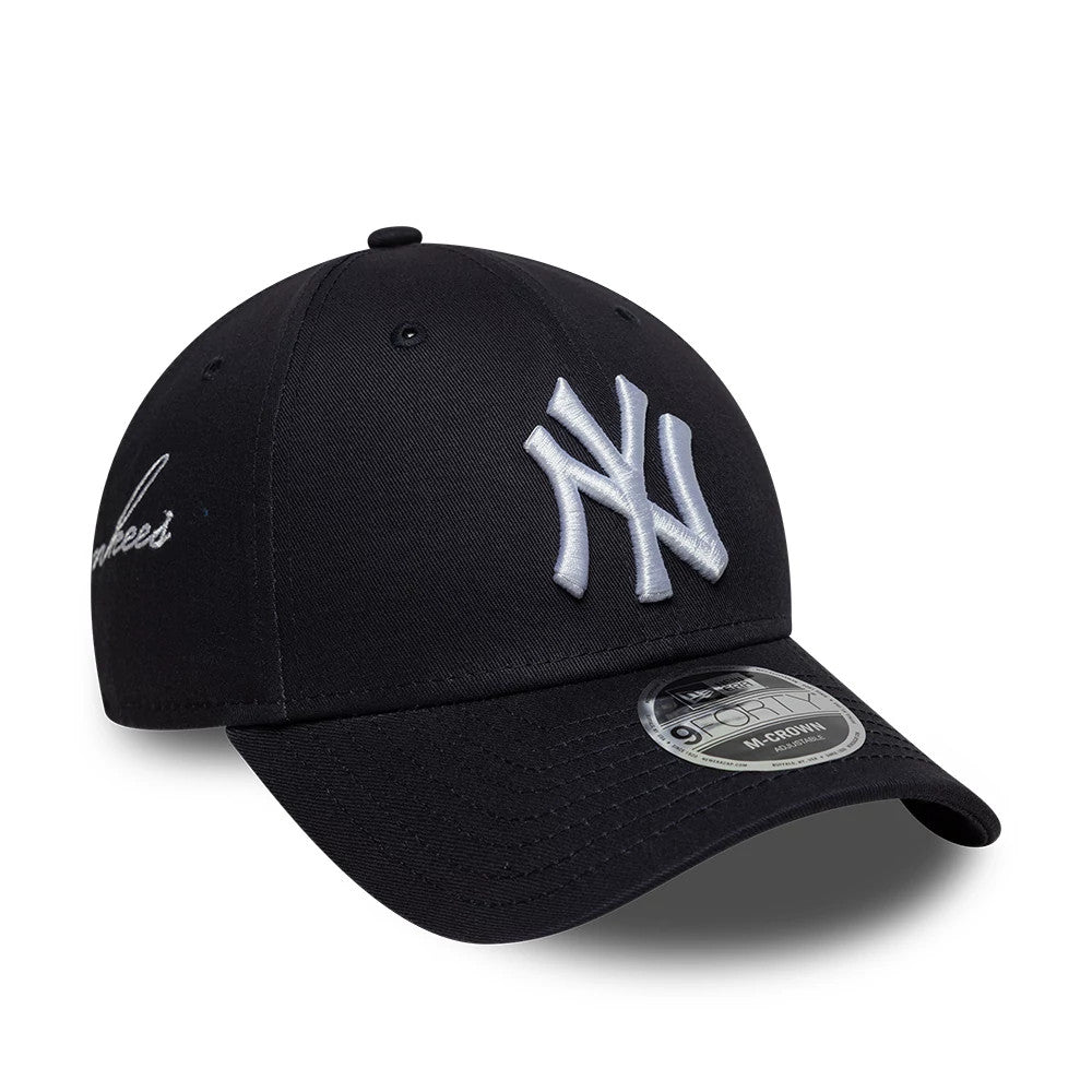 New York Yankees MLB Side Script Navy New Era 9FORTY M-Crown Adjustable Cap, three-quarter view showing raised white NY logo on the front panel, a curved navy visor with 9FORTY size sticker, and Yankees script logo on the left side.