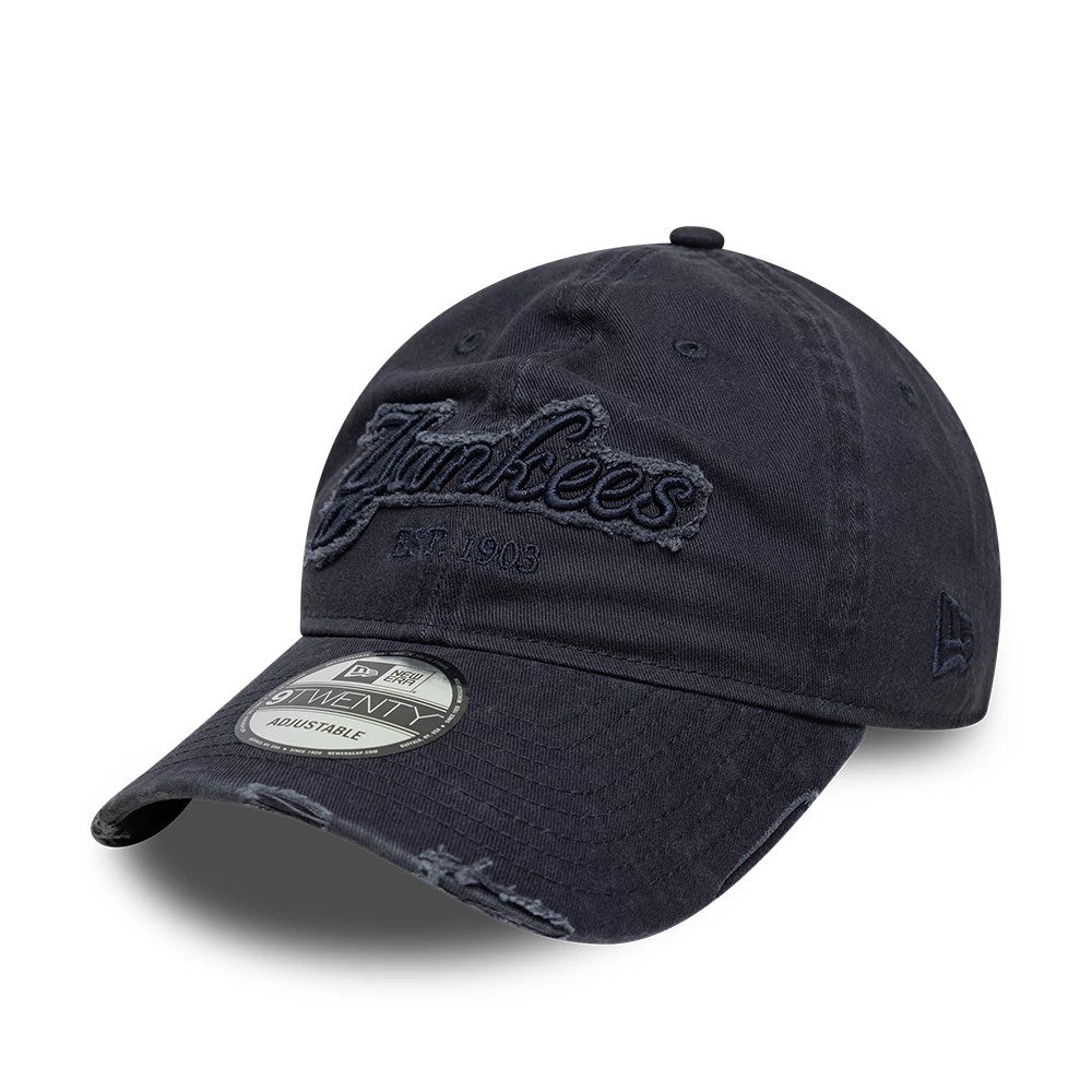 New York Yankees MLB Distressed Denim Navy New Era 9TWENTY Adjustable Cap, three-quarter view showing the frayed embroidered Yankees script logo across the front panels, curved denim visor with distressing.