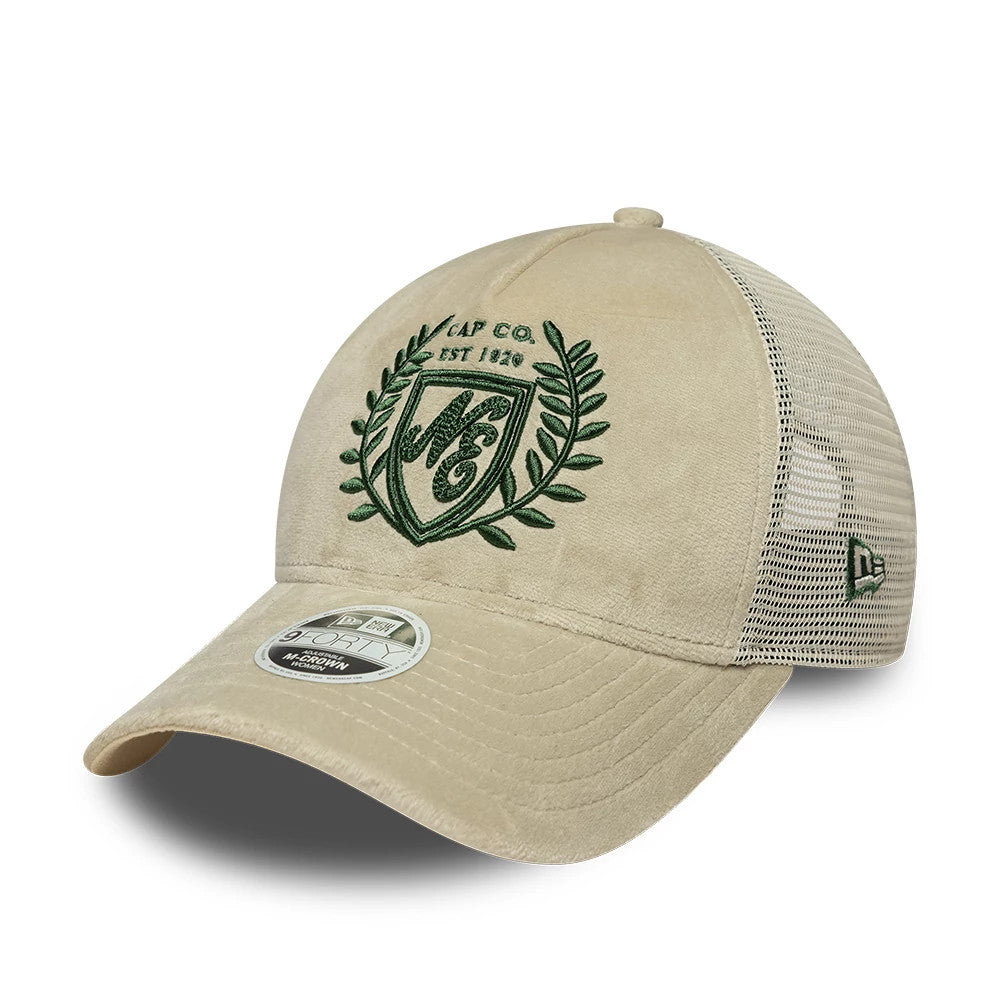 Womens New Era Velour Cream 9FORTY M-Crown A-Frame Trucker Adjustable Cap, front view showing the green embroidered crest and text on the cream velour front panel, paired with a curved visor and 9FORTY size sticker, with mesh material on the sides.