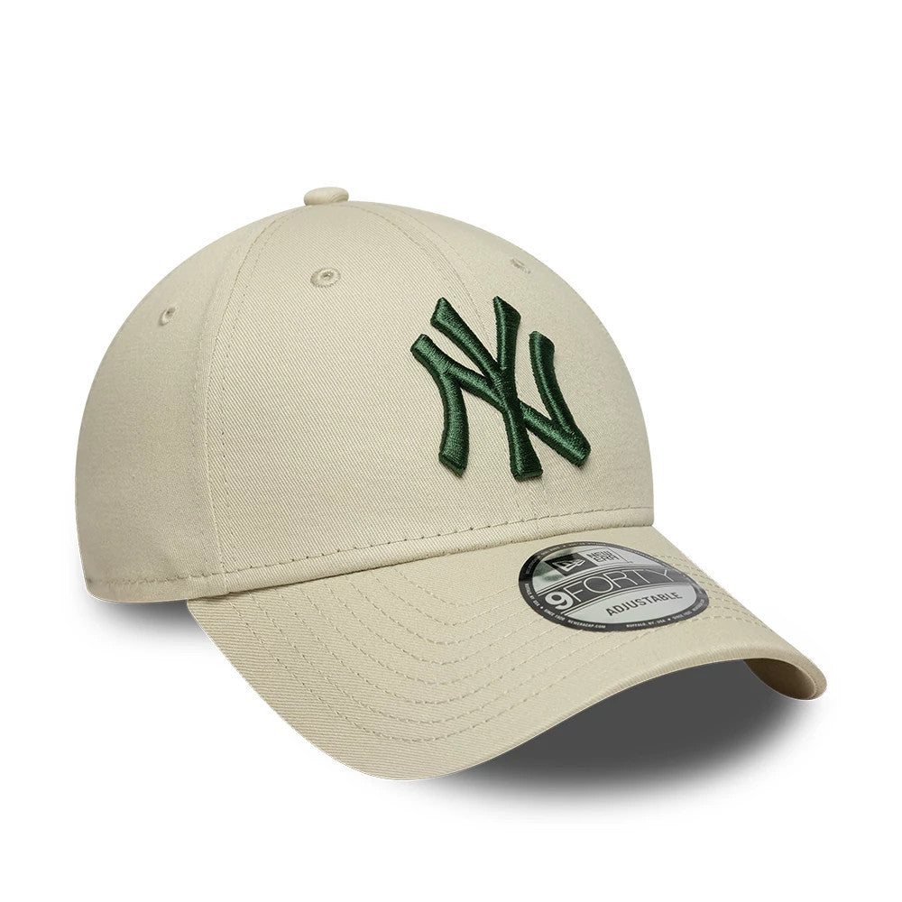 New York Yankees MLB League Essential Cream New Era 9FORTY Adjustable Cap, three-quarter view showing a raised dark green embroidered NY logo on the front panel, a curved visor with a 9FORTY size sticker, and top button matching the cream fabric.