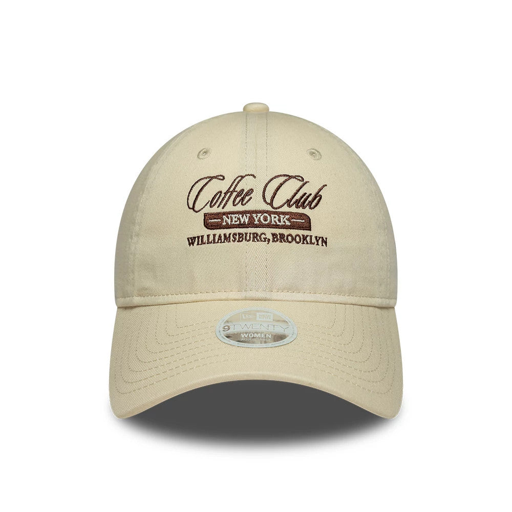 Womens New Era Café Slogan Cream 9TWENTY Adjustable Cap, front view showing a brown embroidered Coffee Club slogan with New York Williamsburg, Brooklyn text below on the structured cream crown, paired with a curved cream visor.